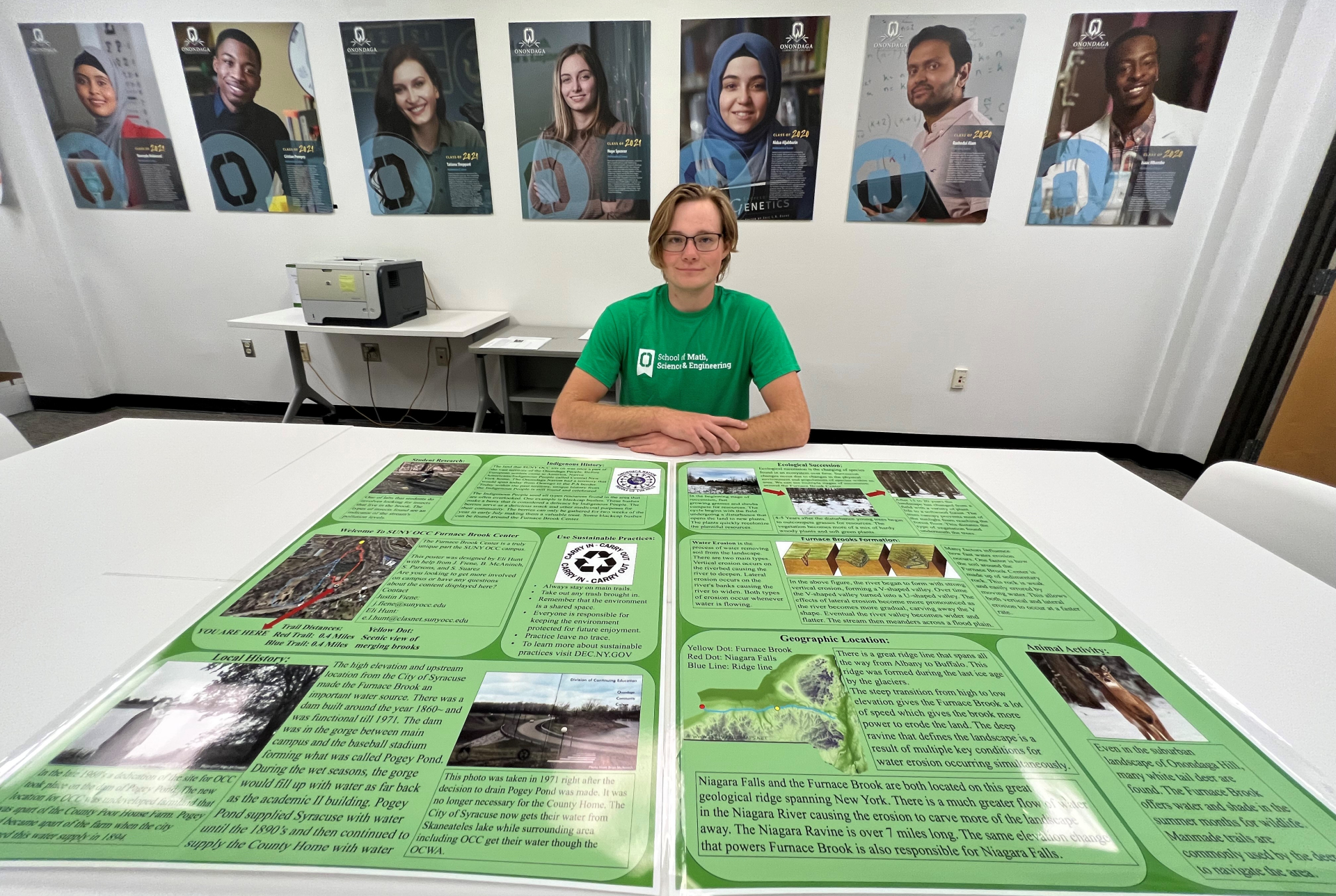 Eli Hunt is pictured with his poster in the School of Math, Science & Engineering.