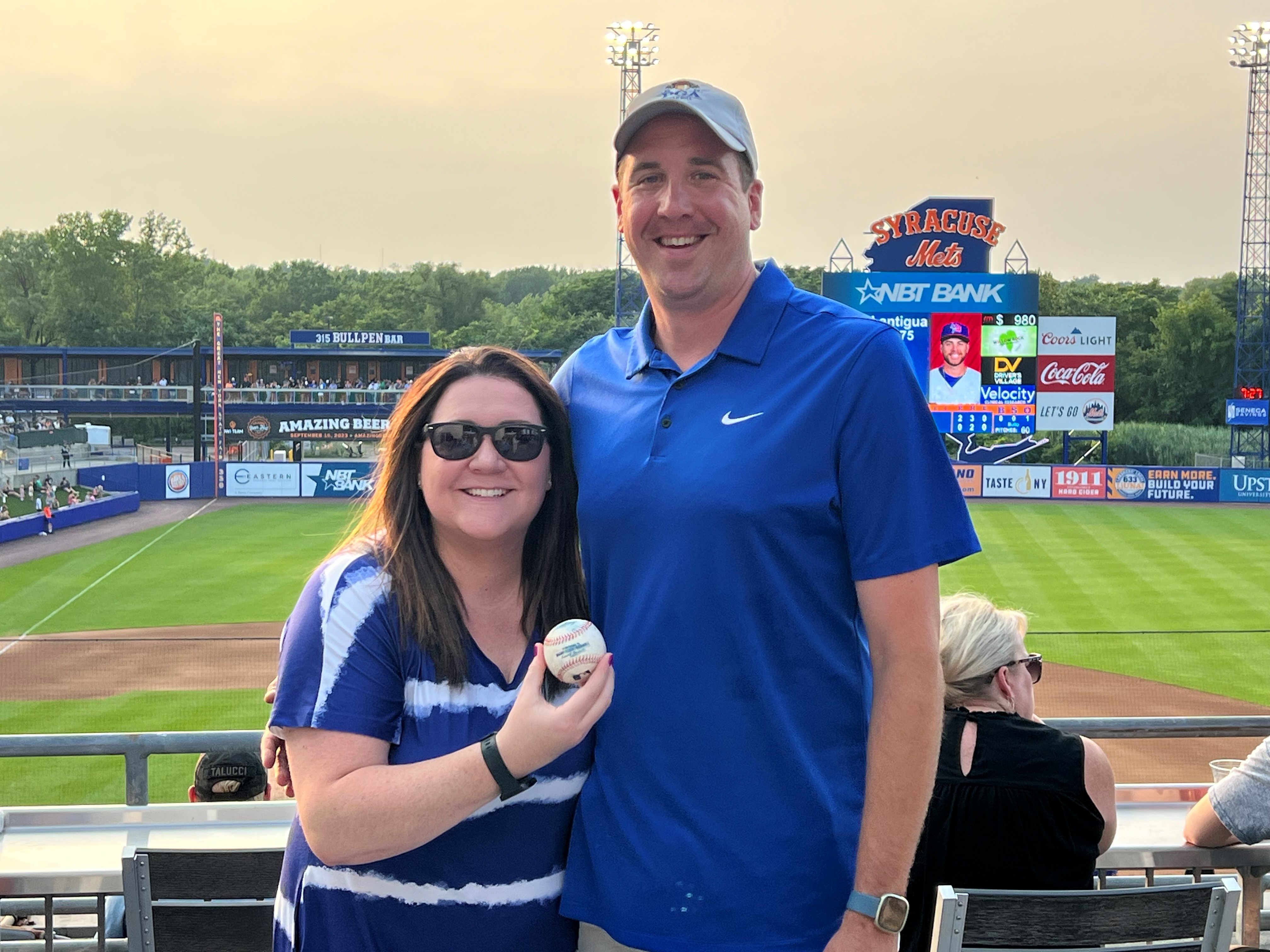 Erin (LaGrow) Yudikaitis '01 and Michael Yudikaitis show off a foul ball that landed in the 1st Base Patio.