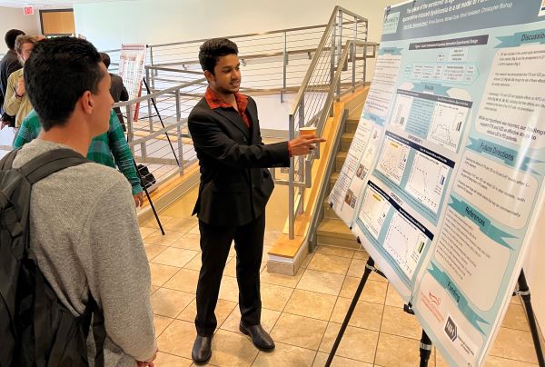 Mohammed Noor (center) talks about the research he conducted at SUNY Binghamton.